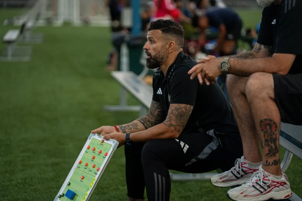 Soccer coach conducting tactical analysis and match planning at Next Play Soccer